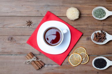 Bir fincan sıcak çay ve baharat ahşap bir masa üzerinde.