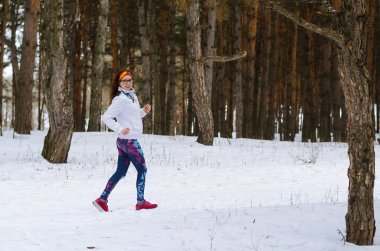 Kış ormanda çalışan spor genç kadın.