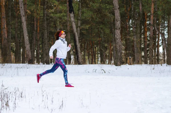 Sport young woman running in the winter forest. — Stock Photo, Image