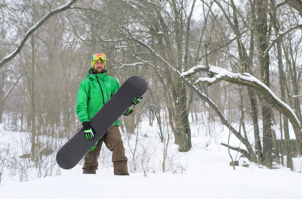 Snowboarder világos ruhát pózol a snowboard. — Stock Fotó