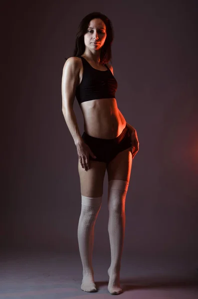 Athletic woman in top and shorts posing on gray background, full — Stock Photo, Image