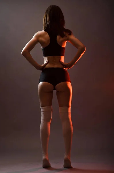Mulher atlética em cima e shorts posando em fundo cinza, cheio — Fotografia de Stock