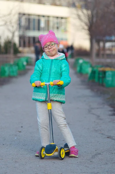 Une petite fille est en scooter . — Photo