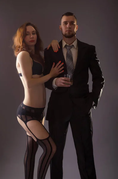 Couple sexy, une femme en bas et un homme en costume . — Photo