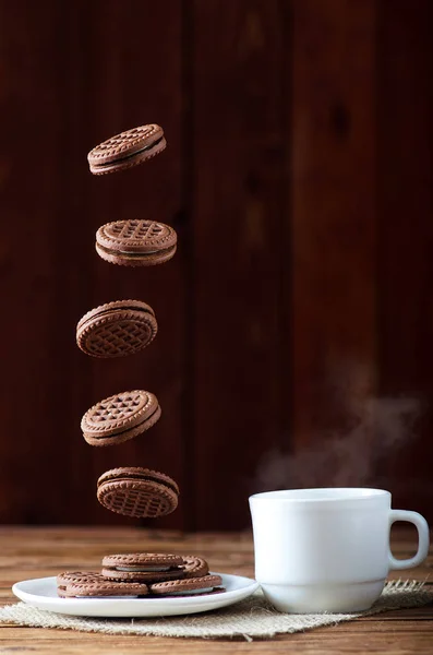 Cookies in flight and a cup of hot tea, close-up on a wooden tab — Stock Photo, Image