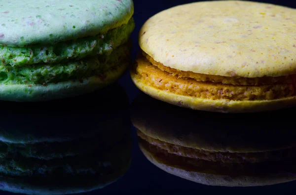 Macarrones multicolores sobre fondo negro con reflejo . — Foto de Stock