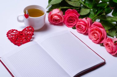 Romantik kavramı: çiçekler, defter ve çay üzerinde beyaz bir ba