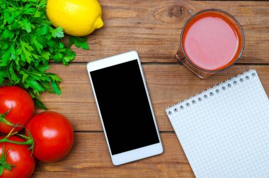 Diyet taze sebze, bir bardak domates suyu ve bir smartpho