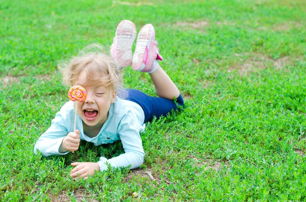 Glückliches kleines Mädchen mit einem Lutscher, freier Raum. ein schönes Kind — Stockfoto