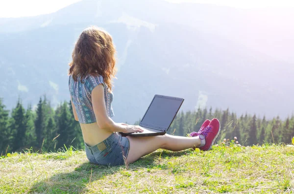 Kobieta z laptopa siedzi na szczycie góry, wolnego miejsca, y — Zdjęcie stockowe