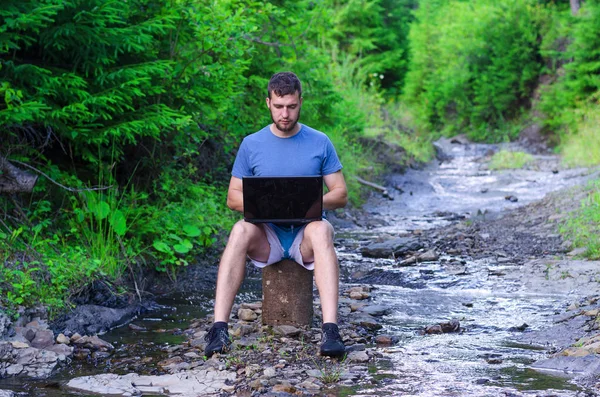 Doğa, boş alan çalışma dizüstü bilgisayar ile genç işadamı.