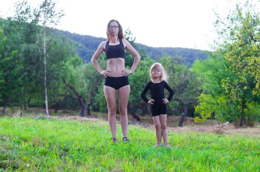 Bir sağlıklı yaşam tarzı, anne ve kızı açık egzersiz yaparak,