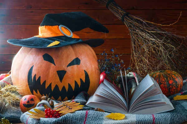 Concept Halloween : une citrouille dans un chapeau, un balai, un livre et un autum — Photo
