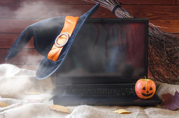 O conceito de Halloween: um laptop, um chapéu de bruxa e uma vassoura, fre — Fotografia de Stock