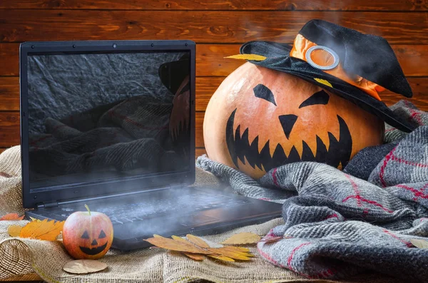 Concept d'un fond d'Halloween : un ordinateur portable et une citrouille dans un w — Photo