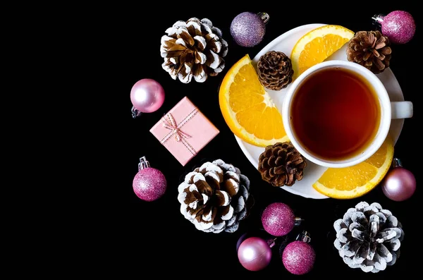 Bolas de Navidad y una taza de té caliente aislado en un backgro negro — Foto de Stock