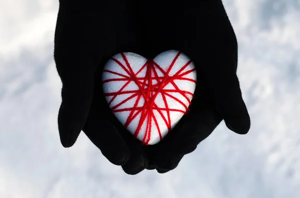 Woman hands holding the heart on a snowy winter. — Stock Photo, Image