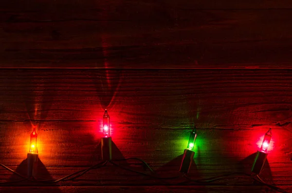 Luzes de Natal em um fundo de madeira vista superior com espaço de cópia — Fotografia de Stock