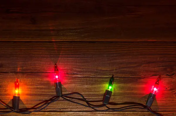 Luzes de Natal em um fundo de madeira vista superior com espaço de cópia — Fotografia de Stock