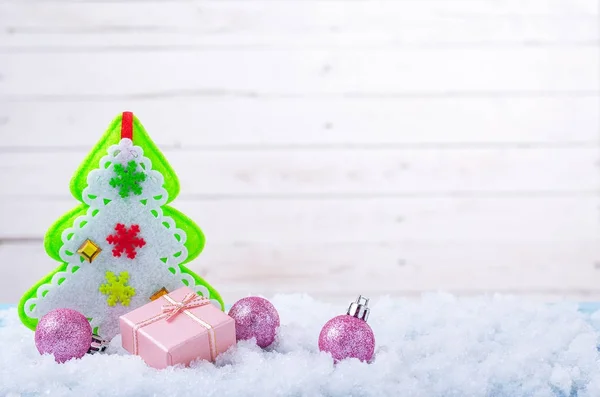Composição de Ano Novo: Árvore de Natal e um presente na neve wi — Fotografia de Stock