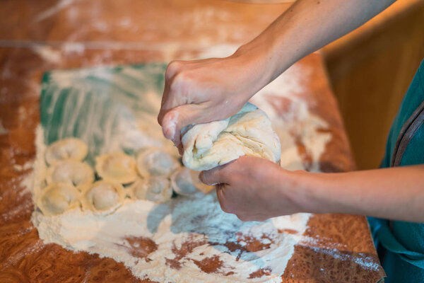 Female hands make home dumplings, close-up.
