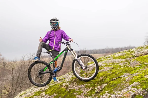 Cycliste tenant un vélo de montagne au-dessus de l'espace libre . — Photo