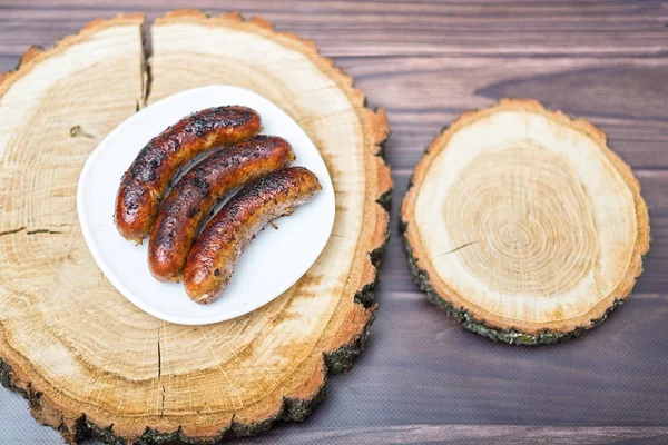 Grilled sausages grilled on a wooden table. — Stock Photo, Image