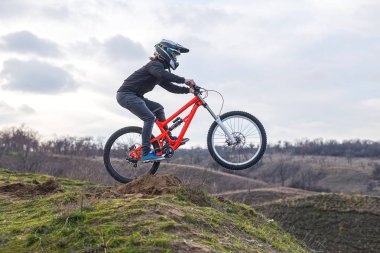 Profesyonel binici arka plan mavi gökyüzü ile bisikletle atlıyor. Güneşli yaz gün.