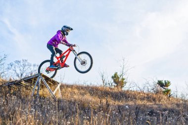 ?yclist yüksek bir sıçrama tahtası, gökyüzü ve metniniz için boş alan üzerinden atlıyor.