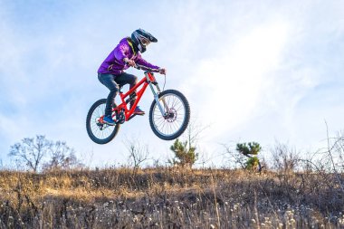 ?yclist yüksek bir sıçrama tahtası, gökyüzü ve metniniz için boş alan üzerinden atlıyor.