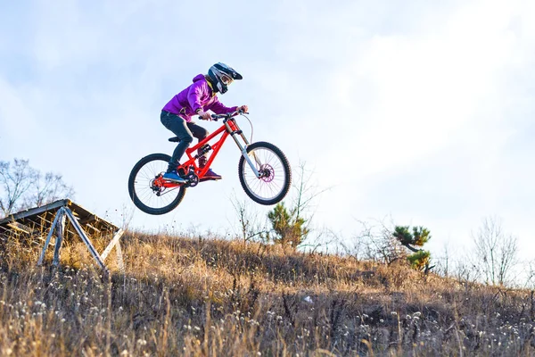 ?Radfahrer springt von einem hohen Sprungbrett, der Himmel und freier Raum für Ihren Text. — Stockfoto