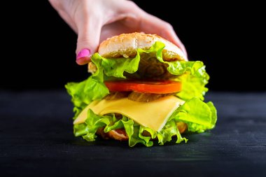 Banner reklam bir masada ahşap siyah, iştah açıcı ve taze burger.
