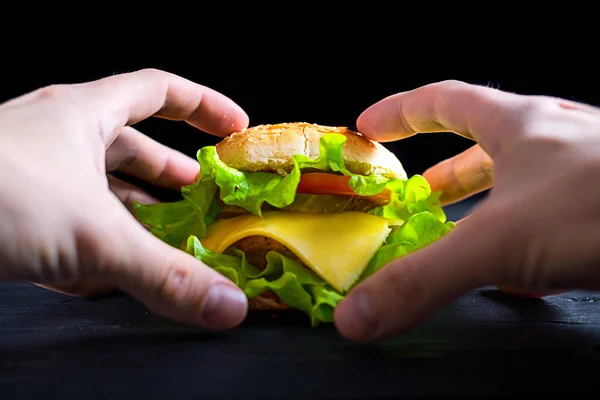 Hambúrguer apetitoso e fresco em uma mesa preta de madeira, banner publicitário . — Fotografia de Stock