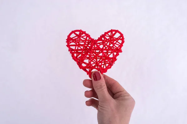 Concepto para el Día de San Valentín, boda: la mano sosteniendo un corazón rojo . — Foto de Stock