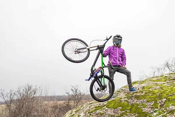 Ciclista sosteniendo una bicicleta de montaña en la parte superior del espacio libre . — Foto de Stock