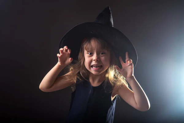 Metniniz için boş alan ile karanlık bir arka plan üzerinde cadı şapkalı güzel kız. — Stok fotoğraf