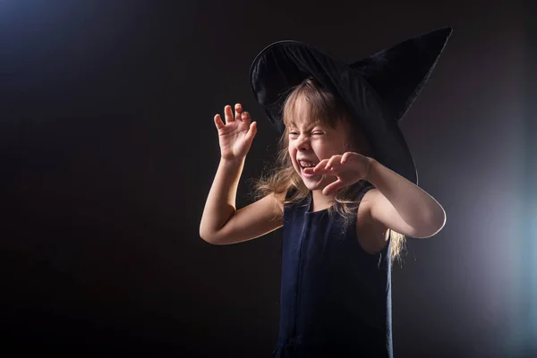 Metniniz için boş alan ile karanlık bir arka plan üzerinde cadı şapkalı güzel kız. — Stok fotoğraf