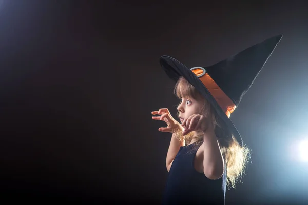 공간이 텍스트에 대 한 어두운 배경에 마녀 모자에서 아름 다운 소녀. — 스톡 사진