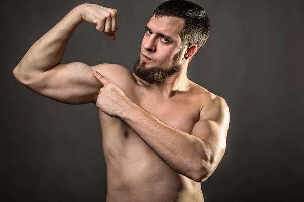 Guapo musculoso culturista sobre un fondo gris . — Foto de Stock