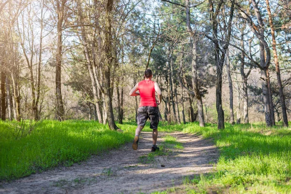 El atleta corriendo a lo largo del sendero forestal, una copia del espacio . —  Fotos de Stock