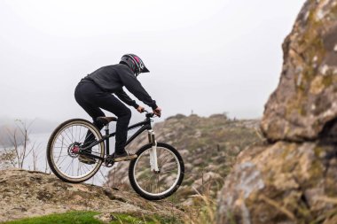 Dağ bisikletçisi kayalıklarda bisiklet sürüyor, ekstrem spor..