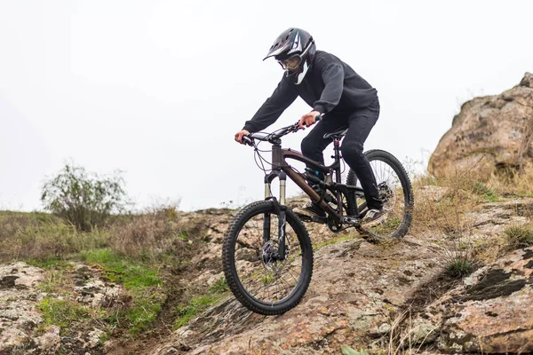 Horský cyklista jezdí na kole na skalách, extrémní sport. — Stock fotografie
