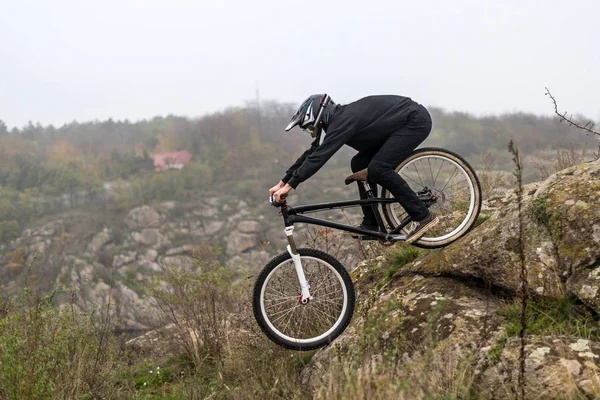 Mountain biker rides a bicycle on the rocks, extreme sport. — Stock Photo, Image