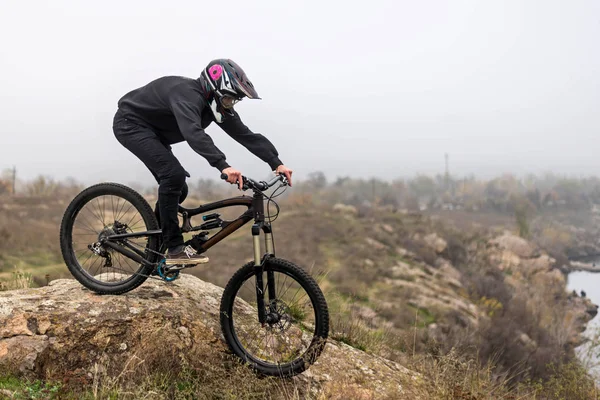 Mountain biker rides a bicycle on the rocks, extreme sport. — ストック写真