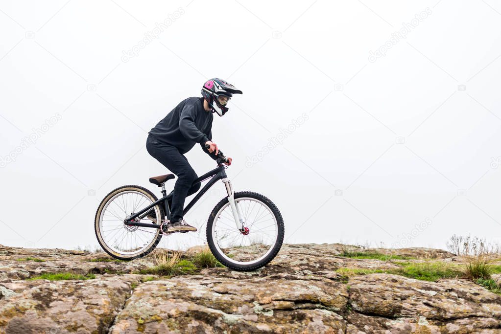 Cyclist riding a mountain bike on rocky terrain.