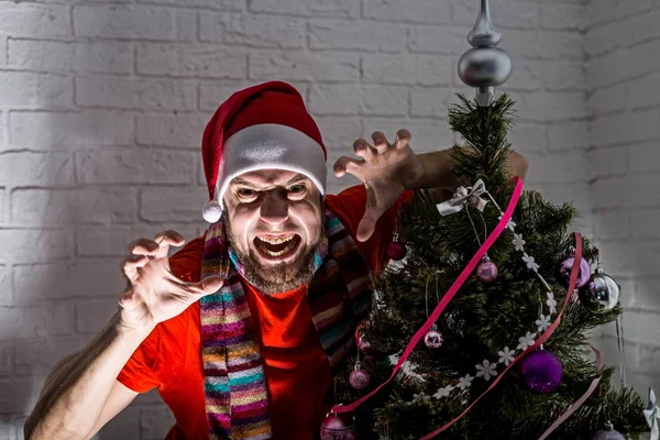 Boze en agressieve Kerstman staat naast de kerstboom. — Stockfoto