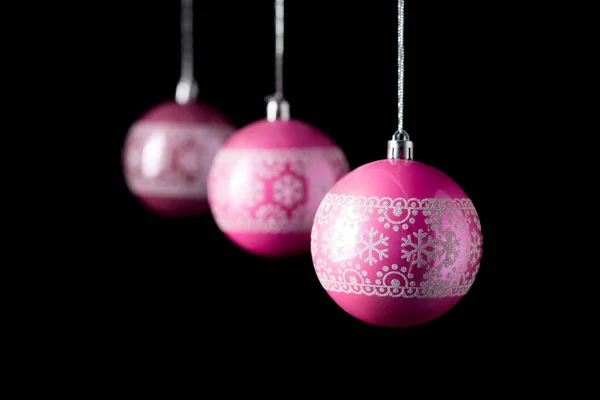 Boules de Noël roses traditionnelles sur fond noir . — Photo