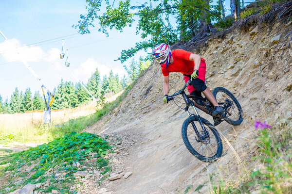 Professional Cyclist Riding the Bike on the Rocky Trail.