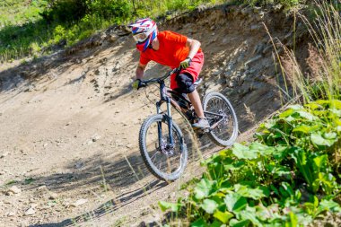 Dağ bisikletçisi yaz ormanlarında bisiklet sürüyor. Mtb akış yolu üzerinde bisiklet süren adam.