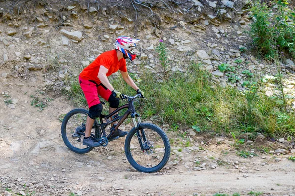 Hegyi kerékpáros kerékpározik a nyári hegyekben erdő táj. Ember kerékpározás Mtb áramlási pálya pálya. — Stock Fotó